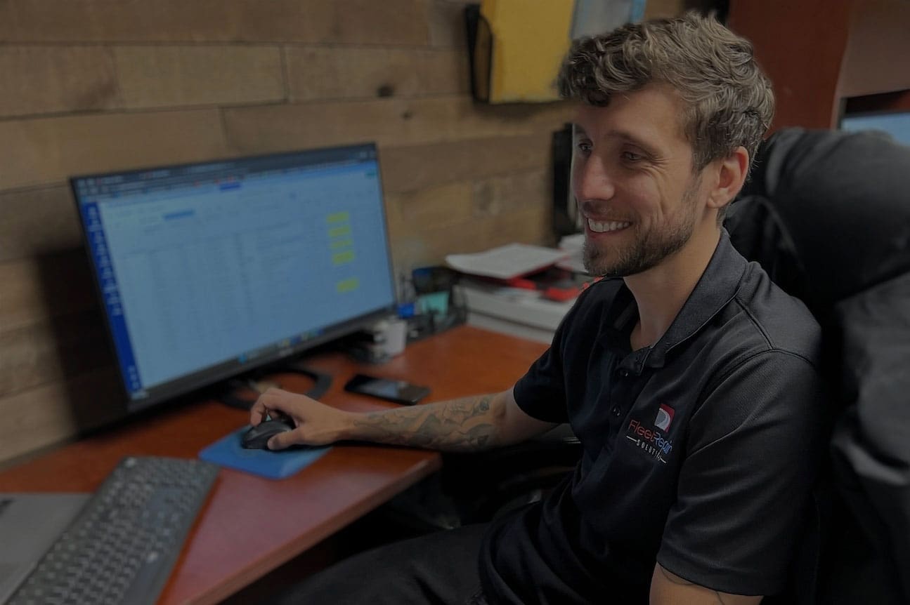Fleet Repair Solutions team member working at a computer and providing customer support.