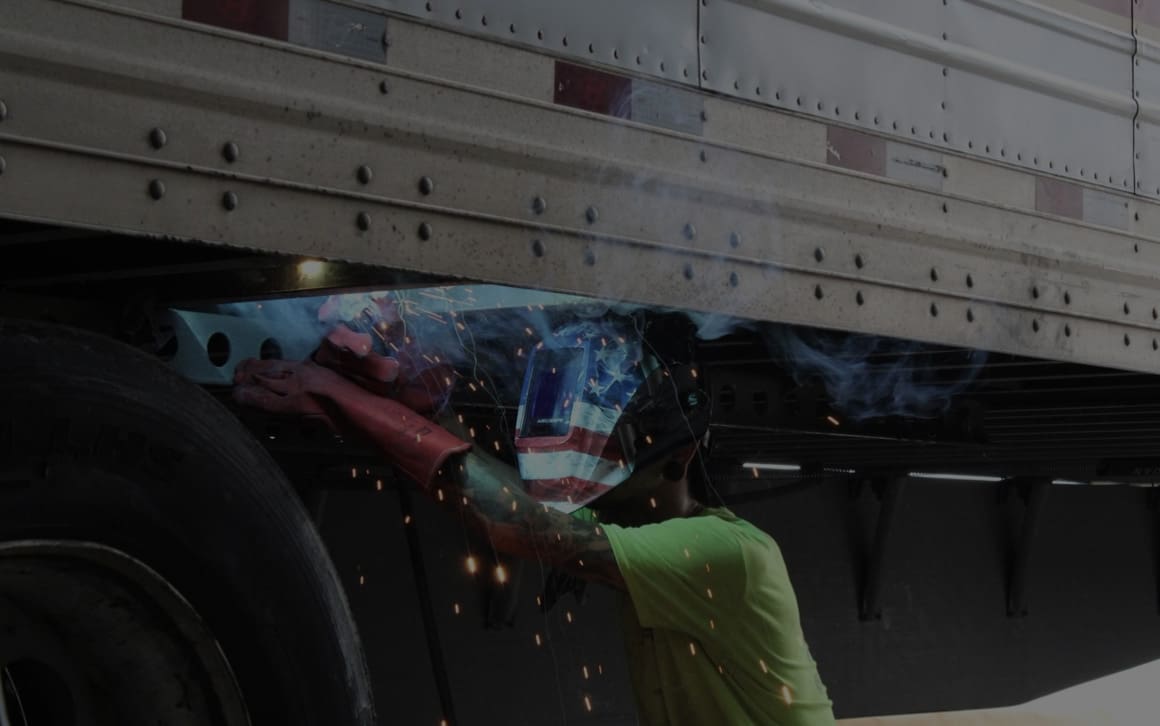 Fleet Repair Solutions technician working underneath a commercial trailer during service.